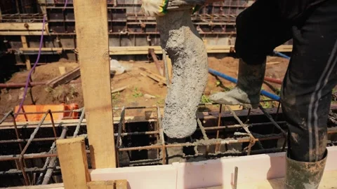 Construction worker pouring concrete into foundation formwork Stock Footage 341294821