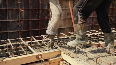 Construction worker pouring concrete into foundation formwork Stock Footage 341294833