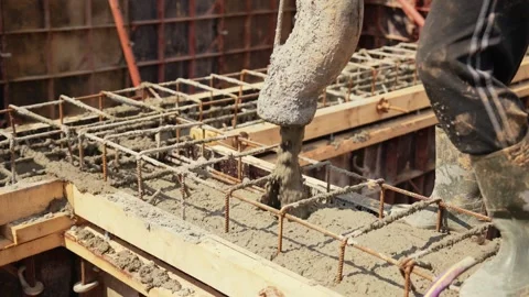 Construction worker pouring concrete into a foundation formwork Stock Footage 341294834