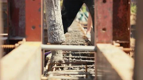 Construction worker pouring concrete foundation at building site Stock Photos