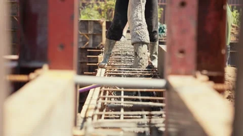 Construction worker pouring concrete into a steel rebar framework Stock Footage 341294591