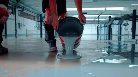 Construction worker pouring epoxy resin on floor Stock Footage 288299139