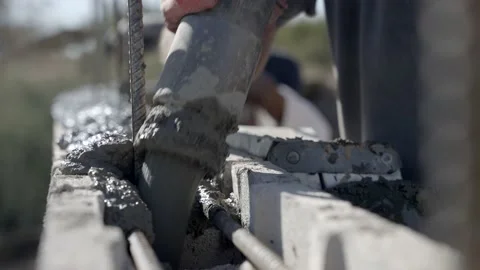 Construction worker pouring wet concrete from pipe into wall formwork, Stock Footage 149165716