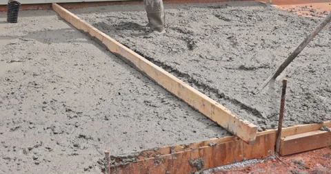 Construction worker pours levels concrete on building site for foundation 動画素材 340408676