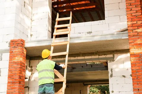 Construction worker prepares to ascend scaffold, house building, organizati.. Stock Photos