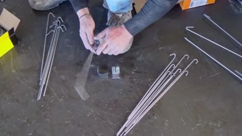 Construction worker prepares with steel rods the pendants to support the plas 動画素材 172215956