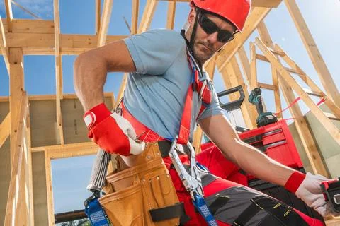 Construction Worker Prepares Tools at Building Site in Bright Sunlight Foto stock