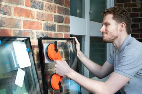 Construction Worker Preparing To Fit Glass Into New Windows Stock Photos