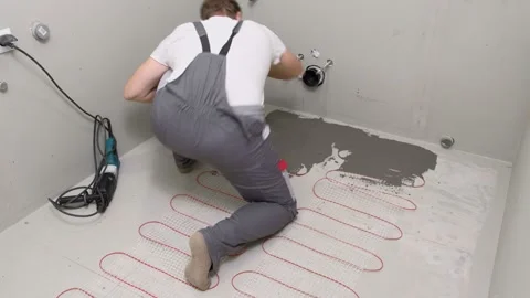 Construction worker preparing tile surface, mixing mortar substrate for flooring Stock Footage 333112785
