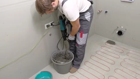 Construction worker preparing tile surface, mixing mortar substrate for flooring Stock Footage 333471187