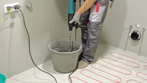 Construction worker preparing tile surface, mixing mortar substrate for flooring Stock Footage 335584565