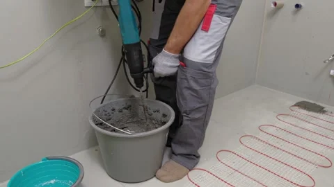 Construction worker preparing tile surface, mixing mortar substrate for flooring Stock Footage 335584669