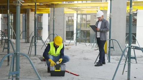 Construction worker preparing tools under supervisor's watch Video stock 343449618