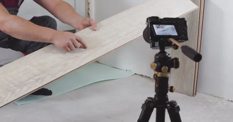 Construction worker presenting laminate flooring to camera Stock Footage 303710653