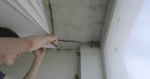 Construction worker pulls ceiling, pulls fabric with force to corner of room Stock Footage 130781125