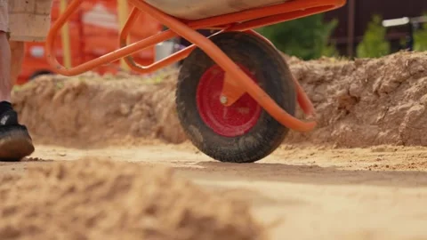 Construction worker pushing wheelbarrow at building site Stock Footage 341294856