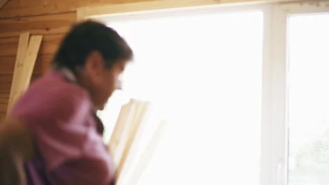 A construction worker puts off a professional tool vest in front of the window Stock Footage 90098004
