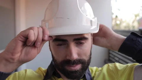 Construction worker putting on hard hat before work and smiling Stock Footage 240392445