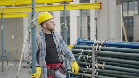 Construction worker putting on hard hat and giving orders 스톡 동영상 337470087