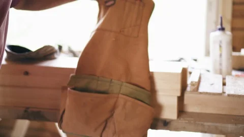 A construction worker is putting on a professional tool vest to start working on Stock Footage 90096584