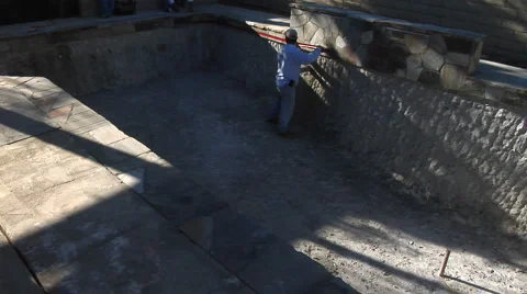 Construction worker putting tape on tile in empty pool Stock Footage 889056