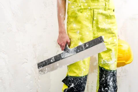 Construction worker with putty knife over obsolete background Stock Photos
