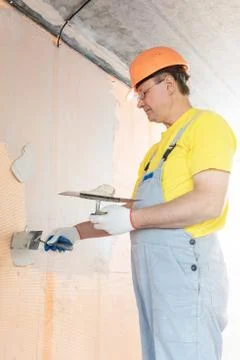 The construction worker putty a wall. Stock Photos