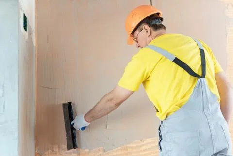 The construction worker putty a wall. Stock Photos