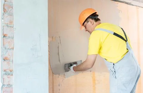 The construction worker putty a wall. Stock Photos