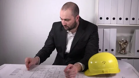 Construction worker reading blueprints writing with pencil architect activity 4K Stock Footage 72900546