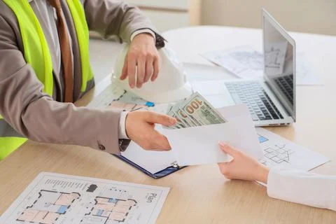 Construction worker receiving cash payment in envelope, business transaction  Stock Photos