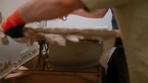 Construction worker removing an old bathroom sink during renovation. Demolition Stock Footage 332185712