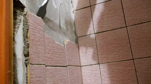 Construction worker removing tiles from bathroom wall Stock Footage 297463046
