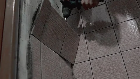 Construction worker removing tiles using electric hammer Stock Footage 297457943