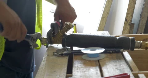 Construction worker repairing the fire sprinkler pipe in a commercial Stock Footage 158910237