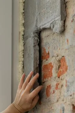 Construction worker repairing an old brick wall using a hammer and chisel Stock Photos