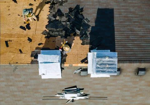 Construction worker on a replacement shingles roof the house installed new sh Stock Photos