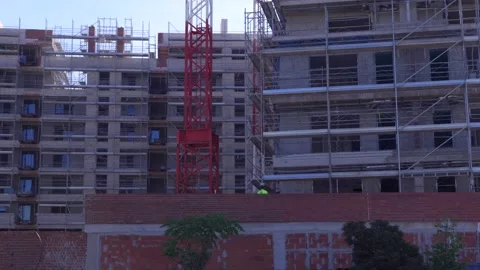 Construction worker at residential building site with crane Stockbeeldmateriaal 335484953