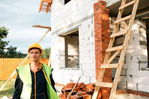 Construction worker reviews plans, checks measurements for building tasks, .. Stock Photos