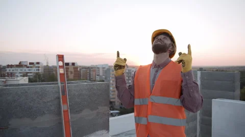 Construction worker reviews progress of building project at sunset Vídeos de archivo 286051731