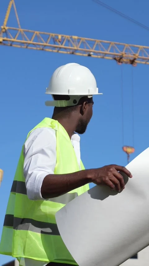Construction Worker Reviews Site Plans. Black Engineer Inspects Plans Nearby 스톡 동영상 332900356