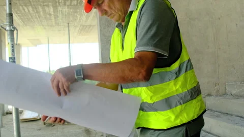 Construction worker rolls up blueprint after study process Stock Footage 317611955