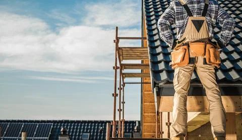 Construction Worker on a Roof Looking Over Building Site in Daylight Fotos Stock