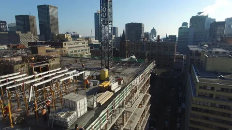 Construction worker on a rooftop with a city on the horizon Stock Footage 64142300