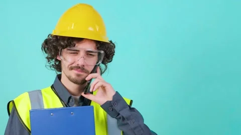 Construction worker with safety glasses and helmet that is talking on mobile Stock Footage 151480624