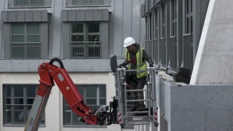Construction Worker with Safety Harness adjusts Cherry Picker Stock Footage 196927390