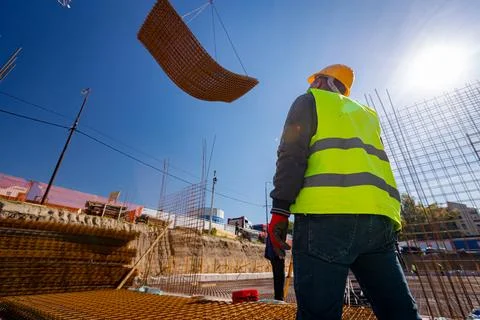 Construction worker with safety helmet at construction site as crane carry .. Stock Photos