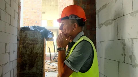 Construction worker in safety vest thinks about work process Stock-Footage 317608837