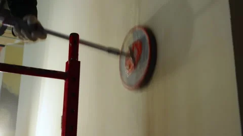 Construction worker is sanding a drywall surface using a long-handle electric Stock Footage 320142686