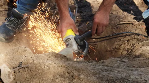 A construction worker saws metal with a bolt cutter and sparks fly Video stock 279334072